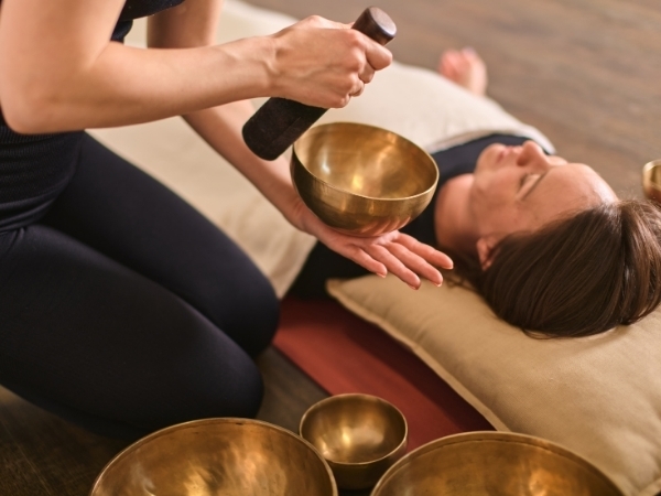 Eine Frau liegt entspannt bei einem Klangbad waehrend eines Vivere Vital Retreats