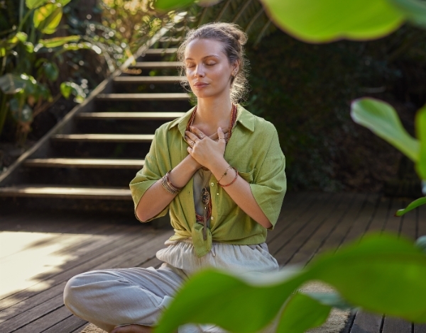 Eine Frau sitzt dankbar bei einem Schweige-Retreat mit Vivere Vital in der Sonne
