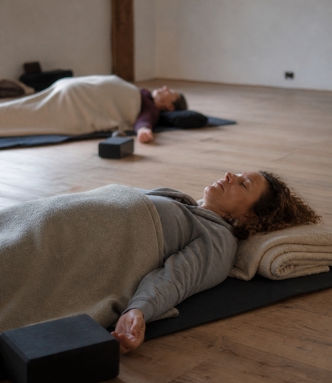 2 Frauen liegen entspannt in einer Yin Yoga Session eines Vivere Vital Retreats